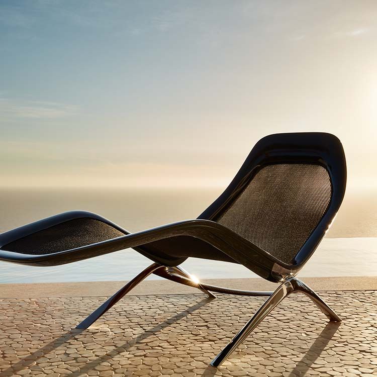 Molded lounge chair on a patio with ocean in background.