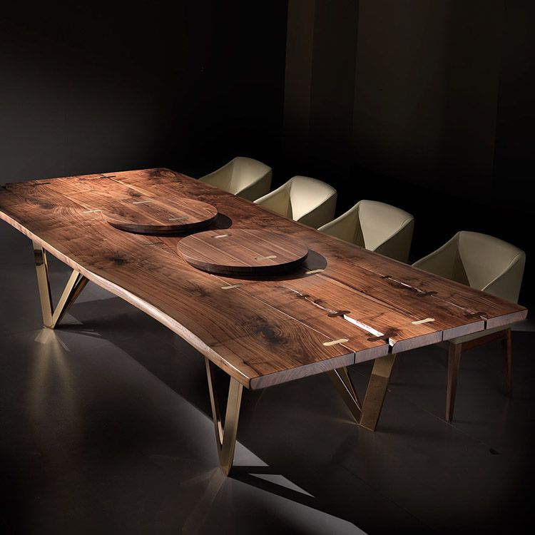 Large wood planked dining table with triangular metal legs.