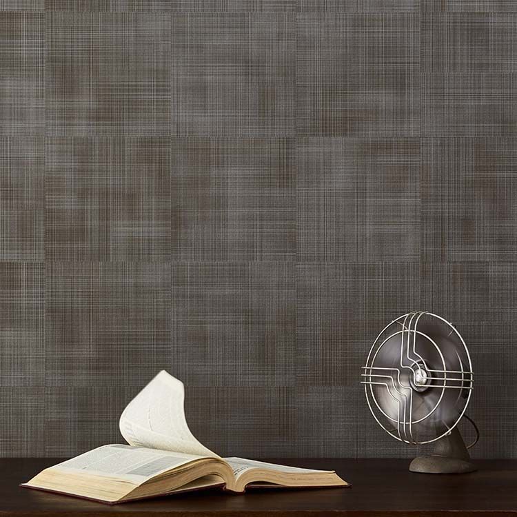 Wallcovering that gives impression of woven fabric in background. In foreground is a vintage table fan in motion blowing the pages of an open hardback book.