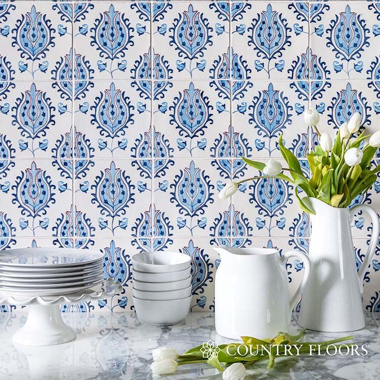 Patterned tile backsplash. In foreground are plates, pitchers and bowls, plus tulips.