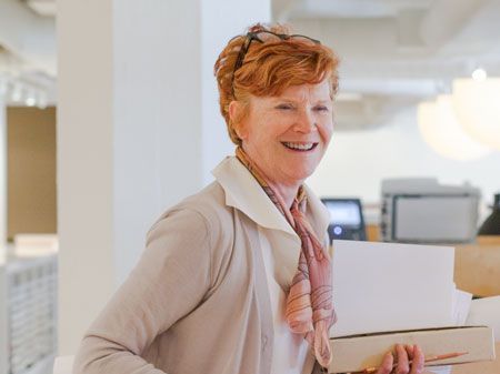 Woman in an office setting smiling for camera.