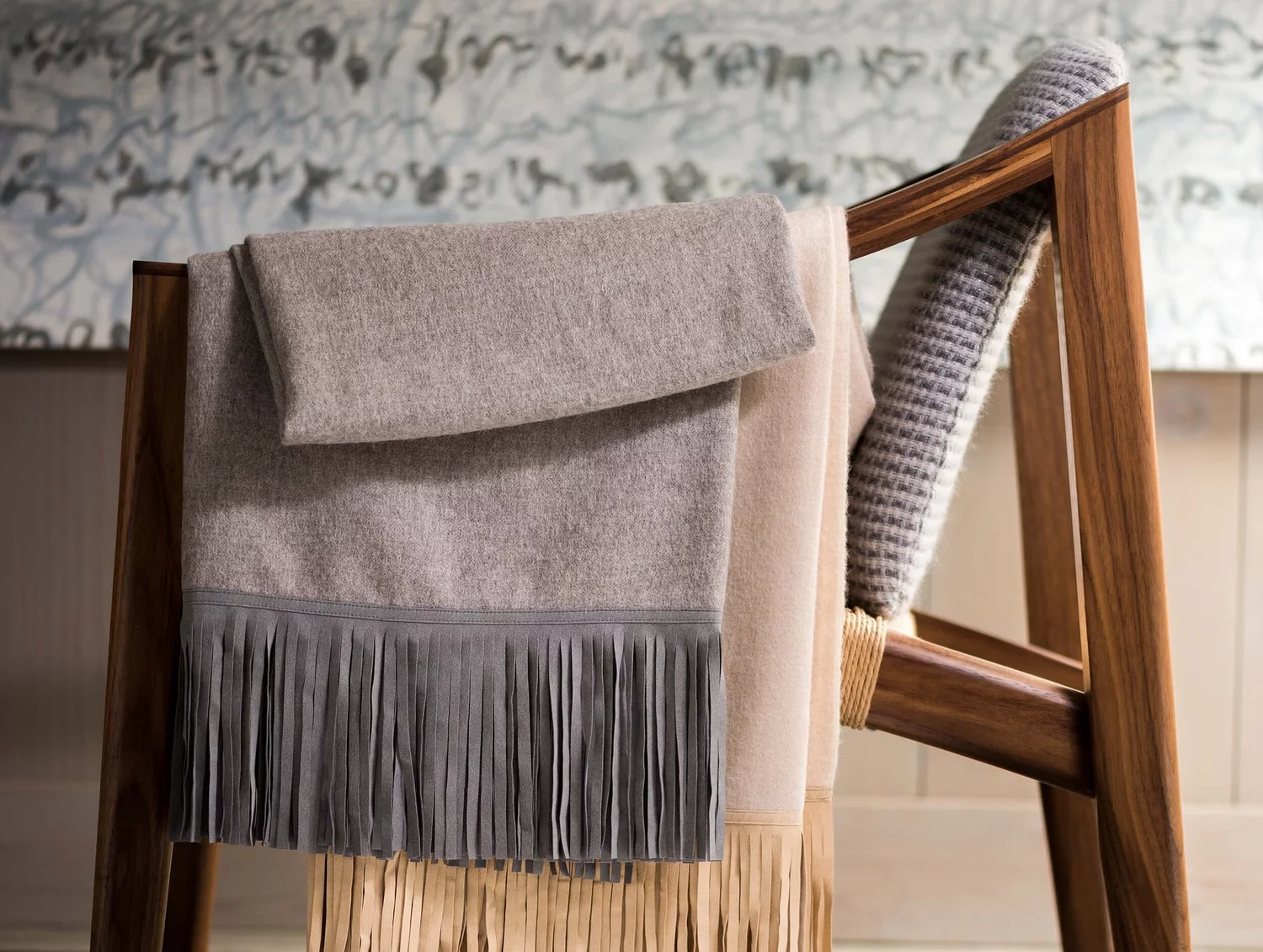 Woven blankets draped over the arm of a chair.
